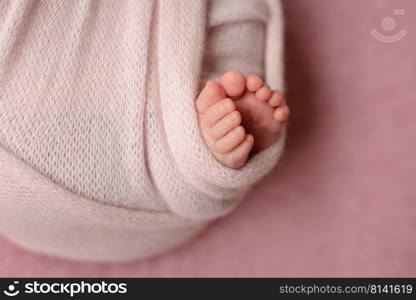 Small beautiful legs of a newborn baby in the first days of life. Baby feet of a newborn. Small beautiful legs of a newborn baby in the first days of life