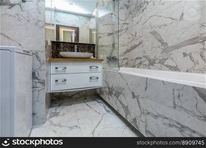 Small beige tile bathroom with bath tube and sink. Small beige bathroom