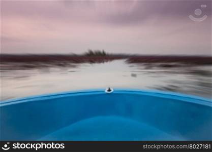 Small boat in the lake of red lotus with blur background, stock photo