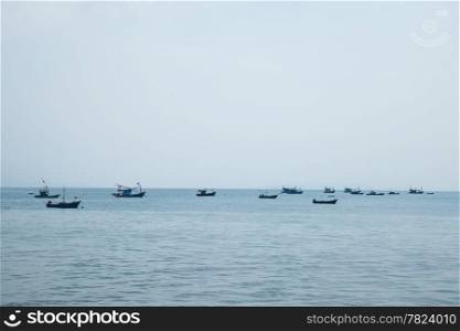 Small boat moored at sea. Small fishing boats moored offshore.