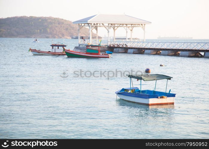 Small boat moored. Behind a wooden bridge into the sea.
