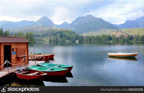 Small boats at pier on mountain lake in Strbske pleso, High Tatras mountain.