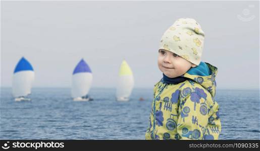 Small boy at seaside watching the regatta