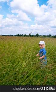 Small boy in tallgrass on summer meadow
