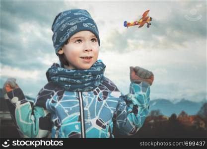 Small boy is looking to small plane in blue sky to let dream fly