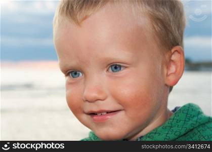 Small boy portrait on evening sandy sea coast