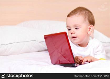 small boy with red laptop at home