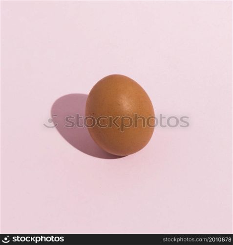 small brown chicken egg pink table