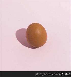 small brown chicken egg pink table