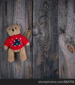 small brown old teddy bear, gray old wooden background, top view