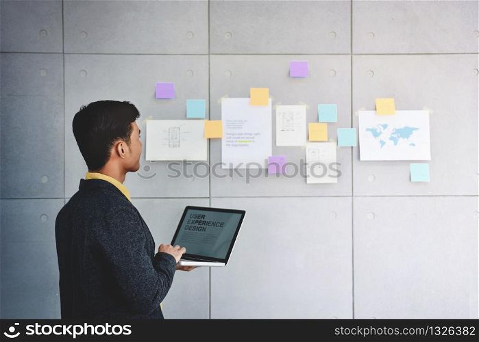 Small Business and Strategy Concept. Young Businessman in Office Meeting Room. Working with Computer Laptop and Document to Analyzing Plans and Project
