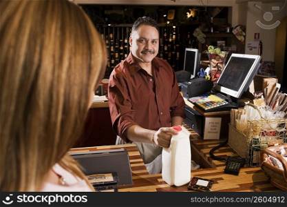 Small business owner checking out customer&acute;s groceries