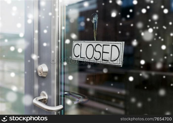 small business, pandemic and service concept - glass door of closed shop or office in winter over snow. glass door of closed shop or office