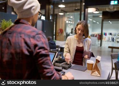 small business, payment, people and service concept - happy woman paying for purchases at cafe. happy woman paying for purchases at cafe