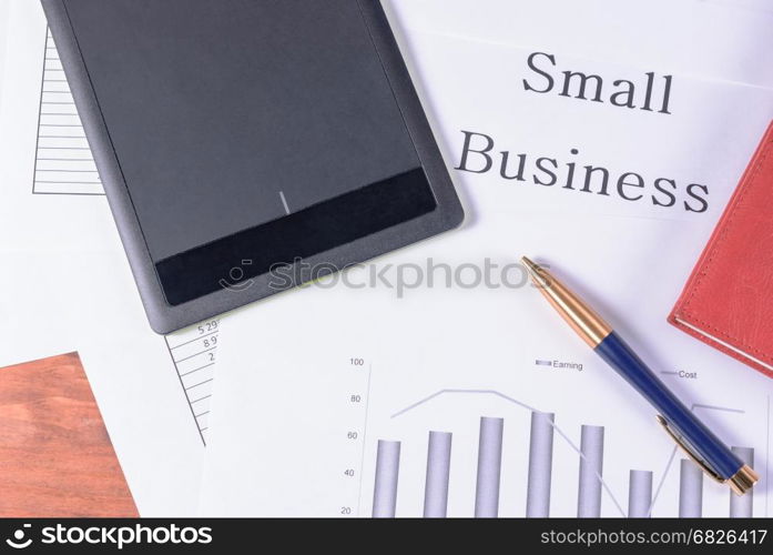 Small business. Pen, red notebook and black tablet. Pen, red notebook and black tablet. Inscription Small business