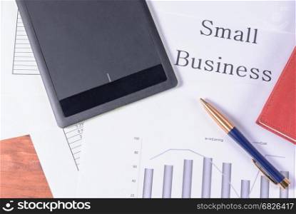 Small business. Pen, red notebook and black tablet. Pen, red notebook and black tablet. Inscription Small business