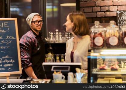 small business, people and service concept - happy bartenders at cafe or coffee shop counter. happy bartenders at cafe or coffee shop counter