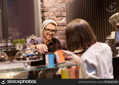 small business, people and service concept - happy female customer buying chai latte instant drink and man or waiter at vegan cafe. happy woman buying chai latte drink at vegan cafe. happy woman buying chai latte drink at vegan cafe