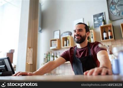 small business, people and service concept - happy man or waiter in apron at bar or coffee shop. happy man or waiter at bar or coffee shop