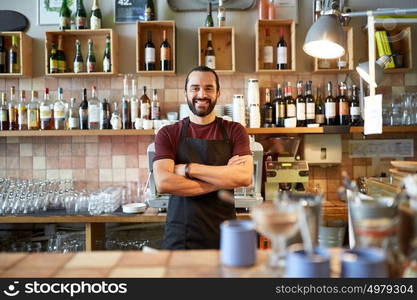 small business, people and service concept - happy man or waiter in apron at bar or coffee shop. happy man, barman or waiter at bar