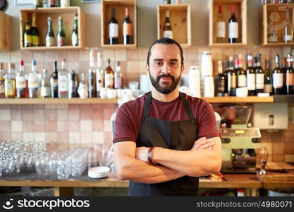 small business, people and service concept - happy man or waiter in apron at bar or coffee shop. happy man, barman or waiter at bar