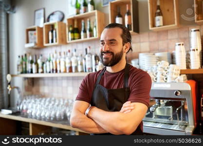 small business, people and service concept - happy man or waiter in apron at bar or coffee shop. happy man, barman or waiter at bar