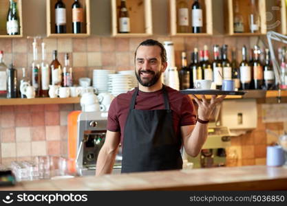 small business, people and service concept - happy man or waiter in apron holding tray with coffee cup and sugar-bowl at bar. happy man or waiter with coffee and sugar at bar