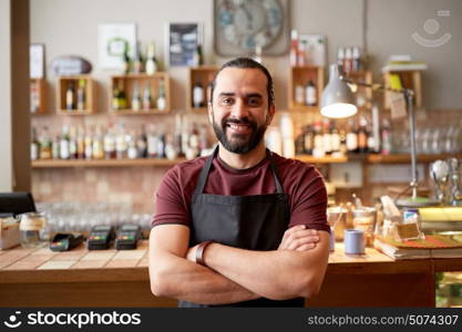 small business, people and service concept - happy man or waiter in apron at bar or coffee shop. happy man, barman or waiter at bar