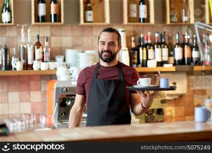 small business, people and service concept - happy man or waiter in apron holding tray with coffee cup and sugar-bowl at bar. happy man or waiter with coffee and sugar at bar