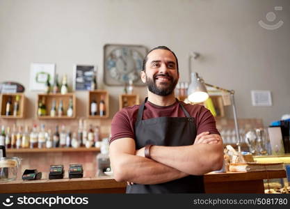 small business, people and service concept - happy man or waiter in apron at bar or coffee shop. happy man, barman or waiter at bar