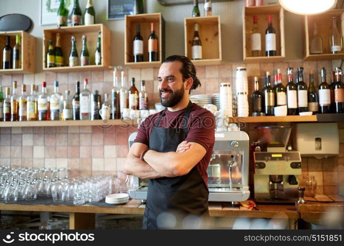 small business, people and service concept - happy man or waiter in apron at bar or coffee shop. happy man, barman or waiter at bar