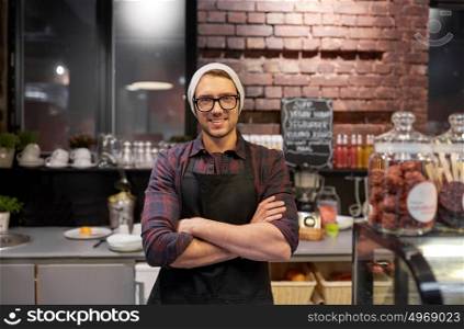 small business, people and service concept - happy seller man or barman at counter in vegan cafe or coffee shop. happy seller man or barman at cafe counter