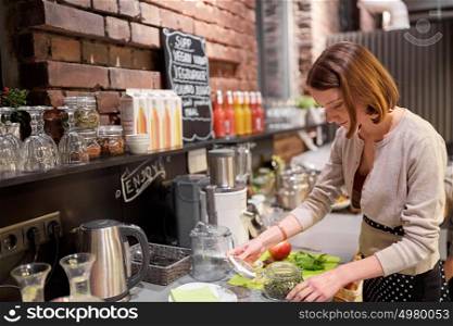 small business, people and service concept - happy woman or barmaid cooking at vegan cafe. happy woman or barmaid cooking at vegan cafe