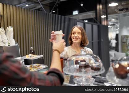 small business, people and service concept - happy woman taking coffee cup from seller at vegan cafe. happy woman taking coffee cup from seller at cafe