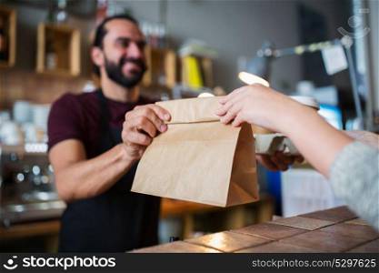 small business, people and service concept - man or bartender serving customer at coffee shop. man or bartender serving customer at coffee shop