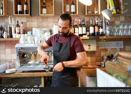 small business, people and service concept - man or waiter in apron with holder and tamper preparing espresso at coffee shop. barista with holder and tamper making at coffee