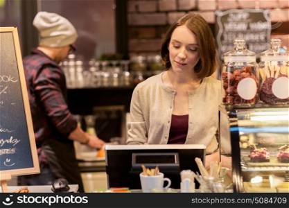 small business, people and service concept - woman or bartender at cafe or coffee shop counter with cashbox. woman bartender at cafe or coffee shop cashbox. woman bartender at cafe or coffee shop cashbox