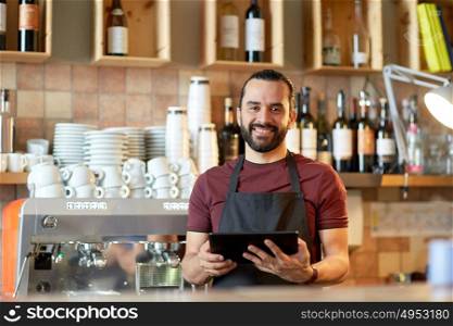 small business, people, technology and service concept - happy man or waiter in apron with tablet pc computer at bar or coffee shop. man, barman or waiter with tablet pc at bar