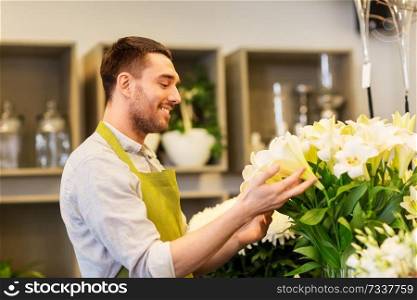 small business, sale and floristry concept - florist or seller with white lilies at flower shop. florist or seller with white lilies at flower shop