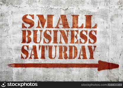 Small business Saturday - graffiti sign with arrow on stucco wall