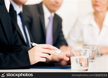 Small business team or working group having a brainstorm meeting in the office, very close-up shots on details, focus on hands in front