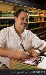 Small businessman taking inventory of grocery items