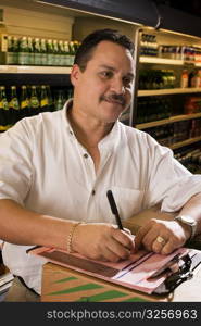 Small businessman taking inventory of grocery items