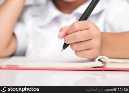 Small businesswoman taking notes while working in the office, close up. Children and business concepts