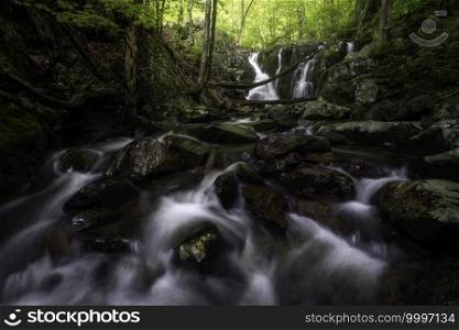 Small cascades with the Rose River Falls in the background within the Central District of Shenandoah National Park on an early June day. T