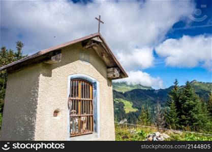 Small chapel in front of a mountain landscape. La Clusaz, France. Small chapel in front of a mountain landscape