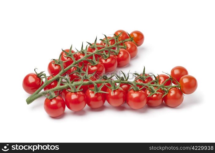 Small cherry tomatoes on a vine on white background
