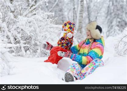 small child and young mother in the winter outside in warm clothes fun