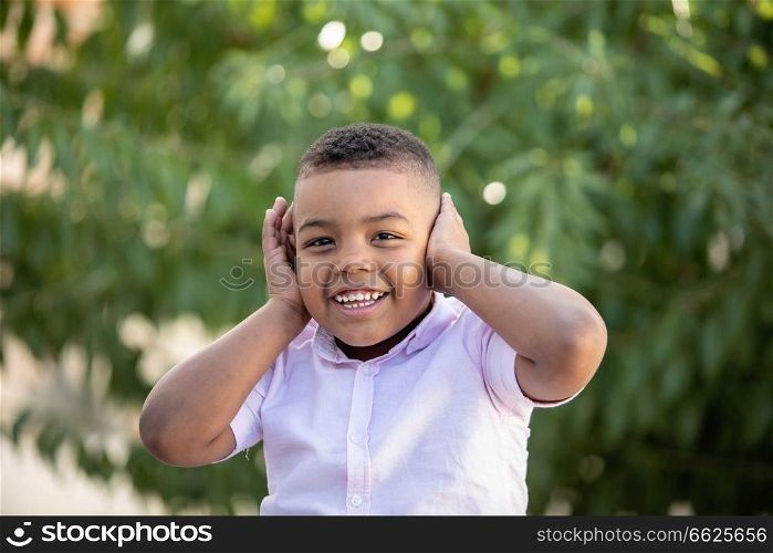 Small child covering his ears in a  beautiful park