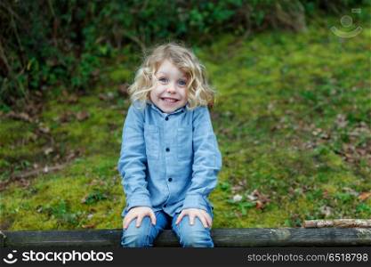Small child enjoying of a sunny day. Small child with long blond hair enjoying of a sunny day